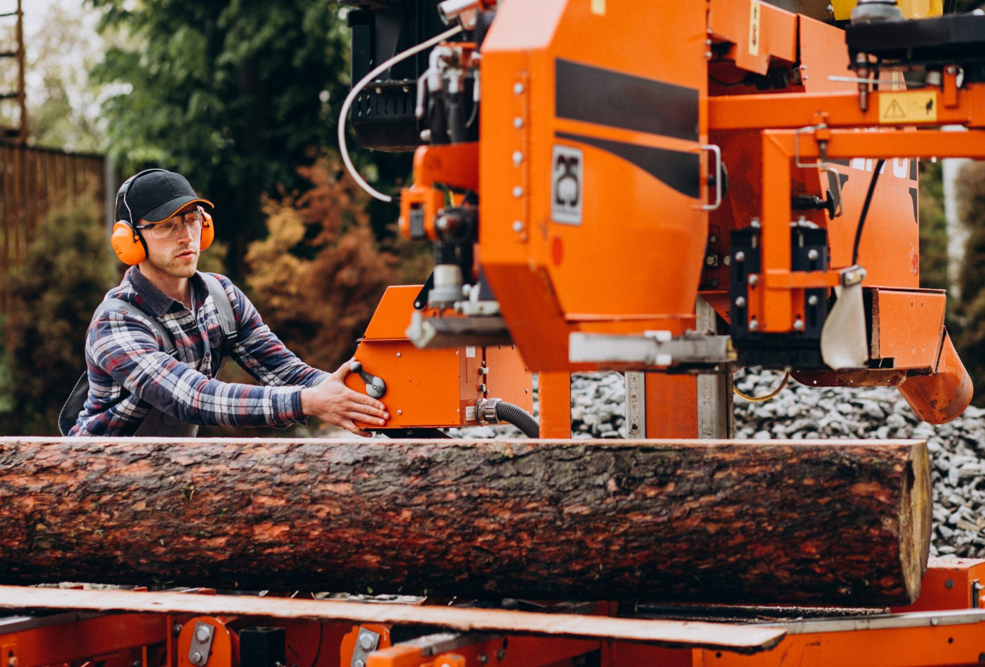 Carpenter working on a sawmill on a wood manufacture